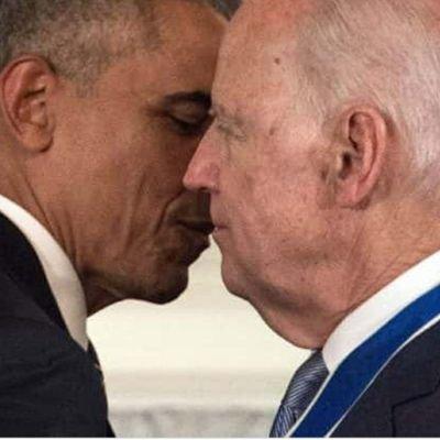 A close-up photo of Barack Obama and Joe Biden with their faces very close together, their noses almost touching.