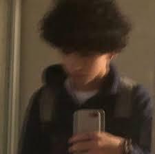 A blurry photo shows a person, with curly dark hair, holding a smartphone and taking a selfie. The text says: "THIS IS MY BF"