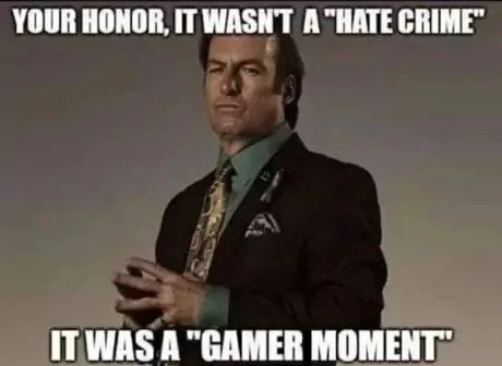 A man in a suit with a serious look is standing in front of a grey background. Above and below him are two text blocks: "Your honor, it wasn't a 'hate crime'" and "It was a 'gamer moment'".