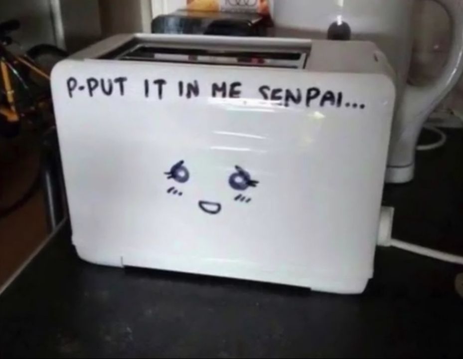 A white toaster with anime-style eyes and mouth drawn on it. Above the drawing, the text 'P-put it in me senpai...' is written.