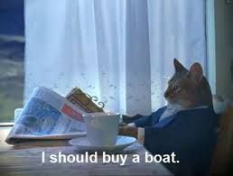 A cat dressed in a suit sits at a table, looking to the side and holding a newspaper and a teacup, with the text "I should buy a boat."