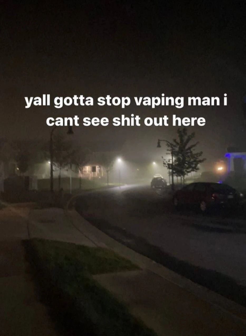 A night scene with a foggy street, houses, and cars with the text: "yall gotta stop vaping man i cant see shit out here".