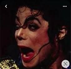 Close-up of Michael Jackson with a shocked expression on his face and his mouth open.