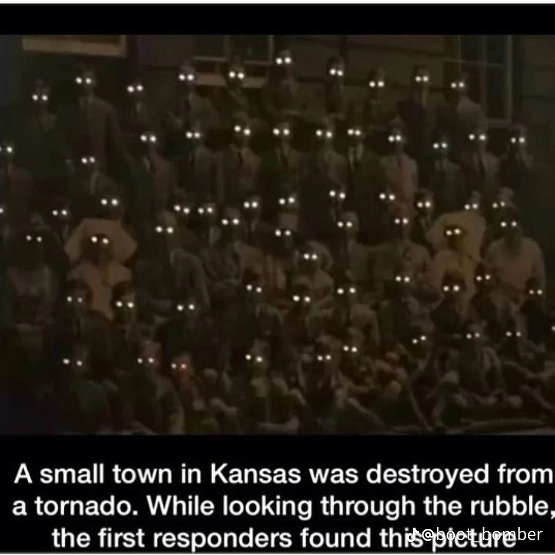 A dark, grainy image of a large group of people sitting and standing. The people are dressed in old-fashioned clothes and have white glowing eyes. Text at the bottom of the image reads: "A small town in Kansas was destroyed from a tornado. While looking through the rubble, the first responders found this picture."