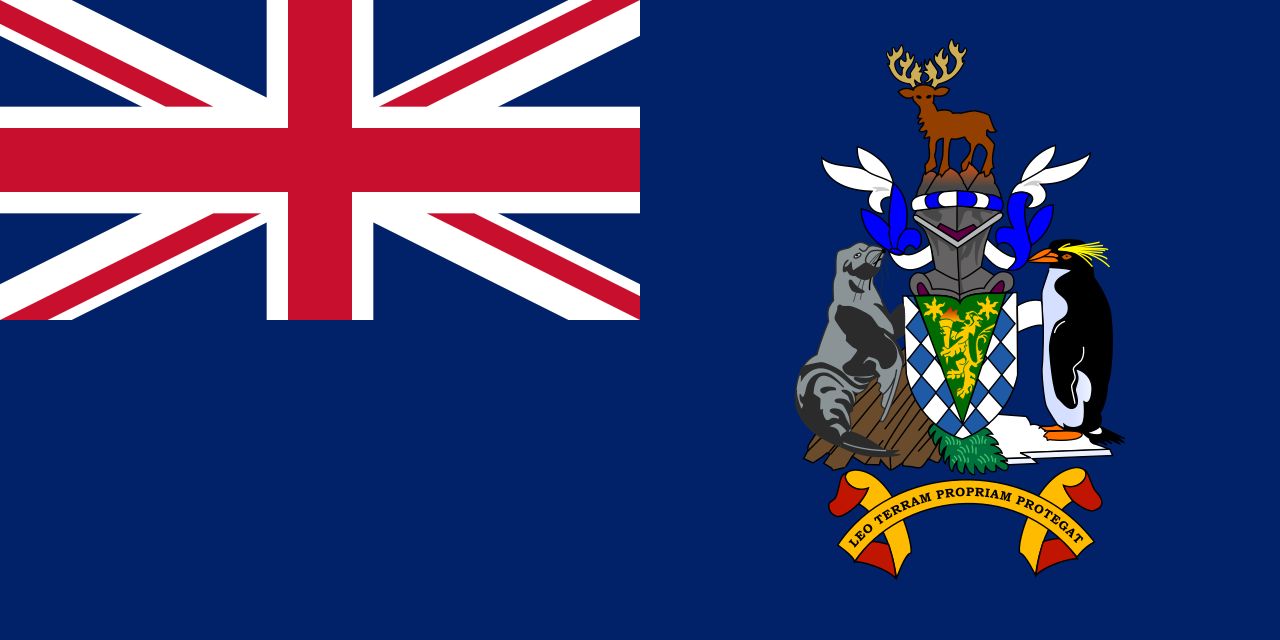 The flag of South Georgia and the South Sandwich Islands. It has a Union Jack in the upper left corner and a coat of arms to the right. The coat of arms features a reindeer, a seal, and a penguin, with the motto "Leo terram propriam protegat" below. The background of the flag is dark blue.