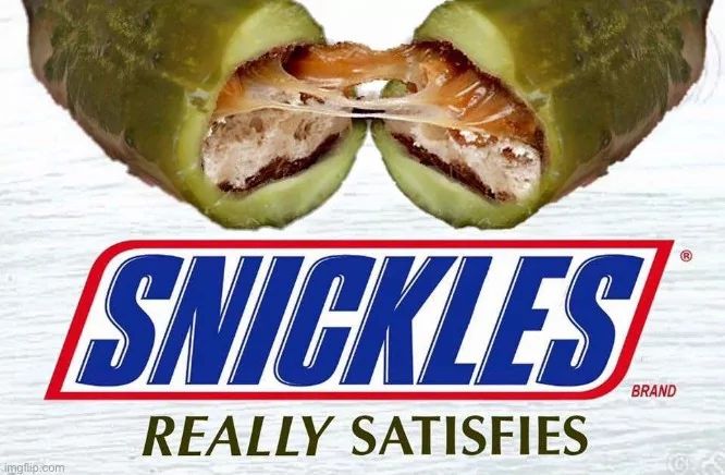 The image shows a halved pickle with what appears to be a Snickers bar inside. Below the pickle is the text "SNICKLES" in the style of the Snickers logo and "REALLY SATISFIES" also in the style of the Snickers logo.